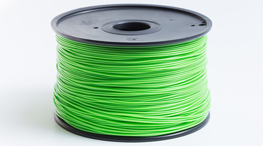 a spool of bright green filament used in 3D printing