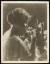 Thumbnail of Photograph of Helen Keller touching and smelling cut flowers.; ci...