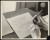 Thumbnail of Photograph of Helen Keller's hands as she writes on paper in penc...