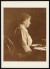 Thumbnail of Photograph taken indoors of Helen Keller sitting at a typewriter.