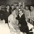 Helen Keller surrounded by smiling soldiers in VA hospital ward, WWII