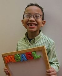 Young boy holds a magnetic board with his name