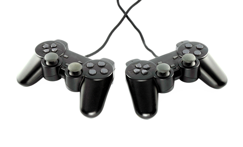 Two video game controllers, wires crisscrossed.