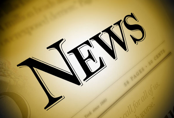 Close-up of a newspaper with the word 'News' emphasized in black on a brown/gold background. 