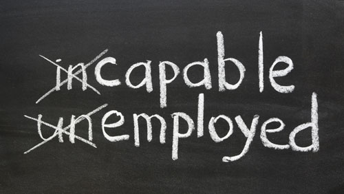 The words 'incapable' and 'unemployed' on a chalkboard, with 'in' and 'un' crossed out to spell 'capable' and 'employed.'