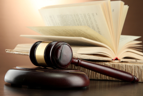 Wooden gavel and books on wooden table,on brown background.