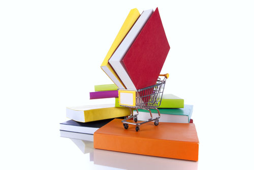 Stack of books and a shopping cart. The cart holds a pair of books.