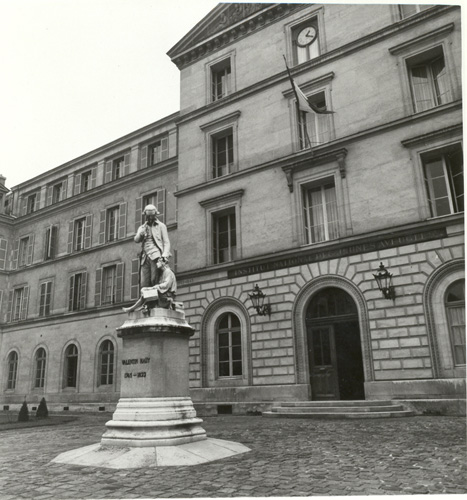 Photograph of the exterior facade of the Institute for Blind Youth at 68 rue Saint-Victor in Paris. The building was constructed in 1843. Louis lived and taught here. A statue, seen here in the building's courtyard, is of the school's founder, Valentin Haüy, standing next to his seated pupil, Francois Le Sueur. No date.