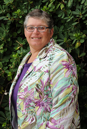 Photo of Dr. L. Penny Rosenblum . She is a white woman with short hair wearing a white shirt and glasses smiling at the camera. 