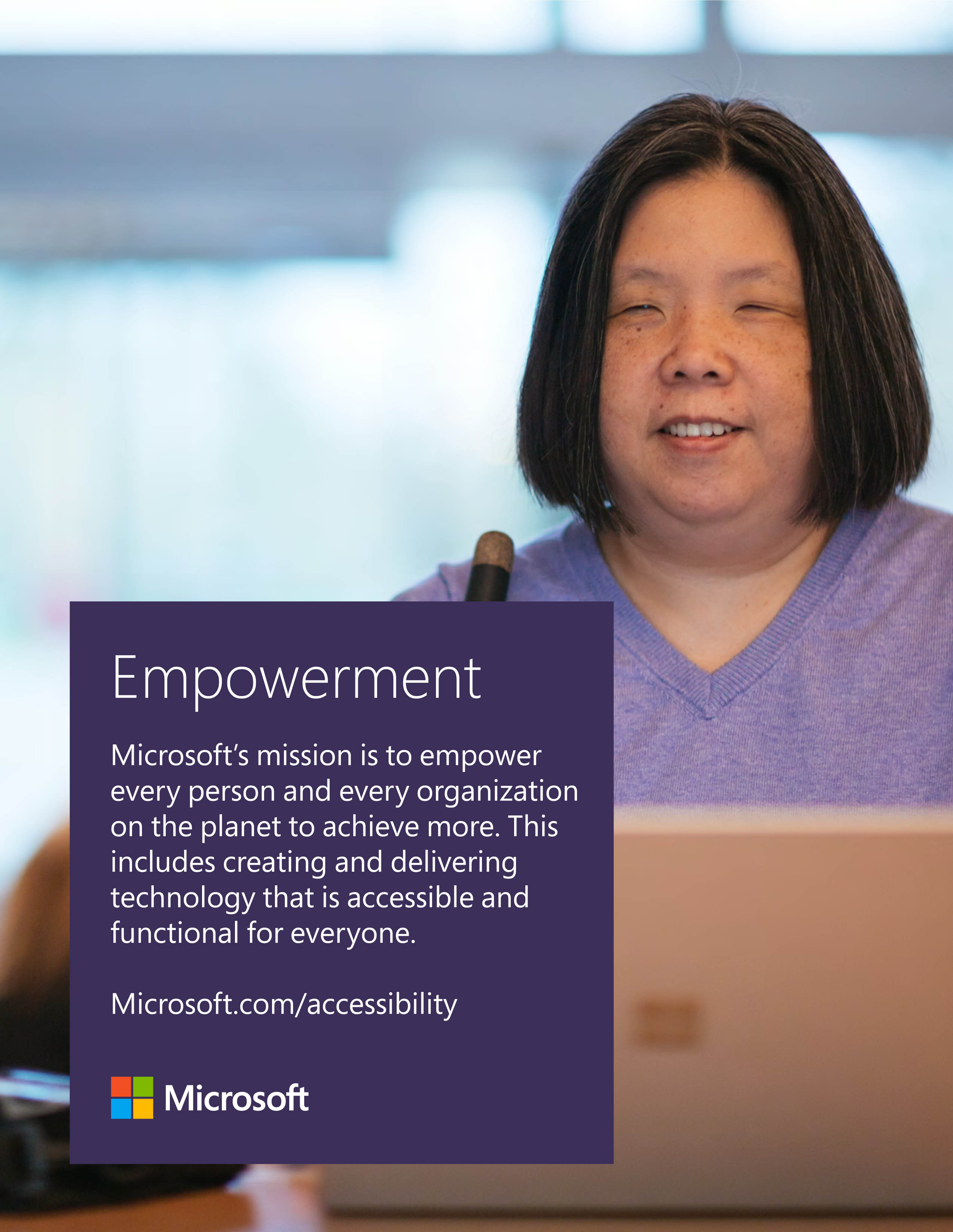 Image: A middle-aged Asian woman with blindness smiles while using a laptop computer.