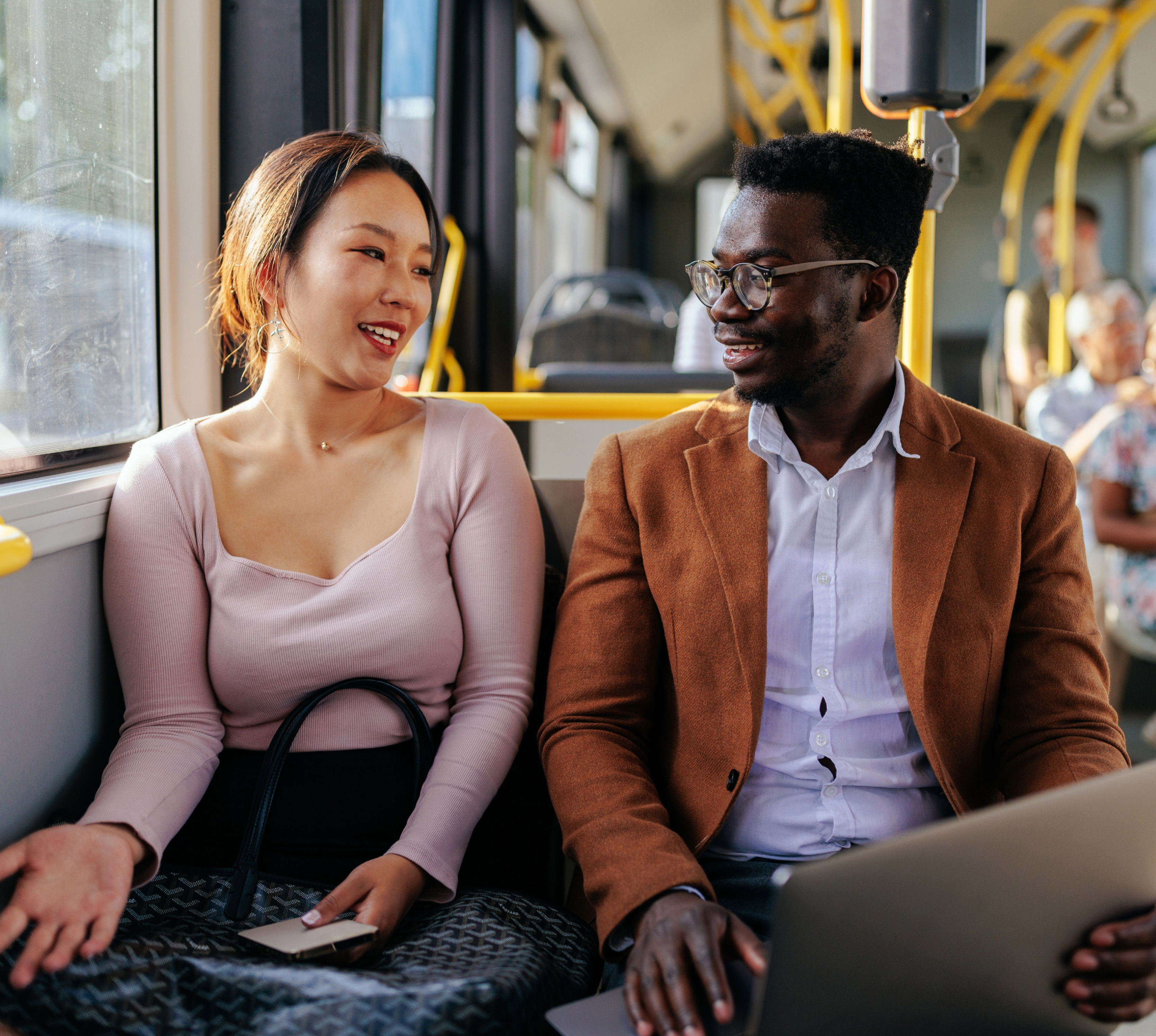 A woman and a man talk while sitting together on a bus.