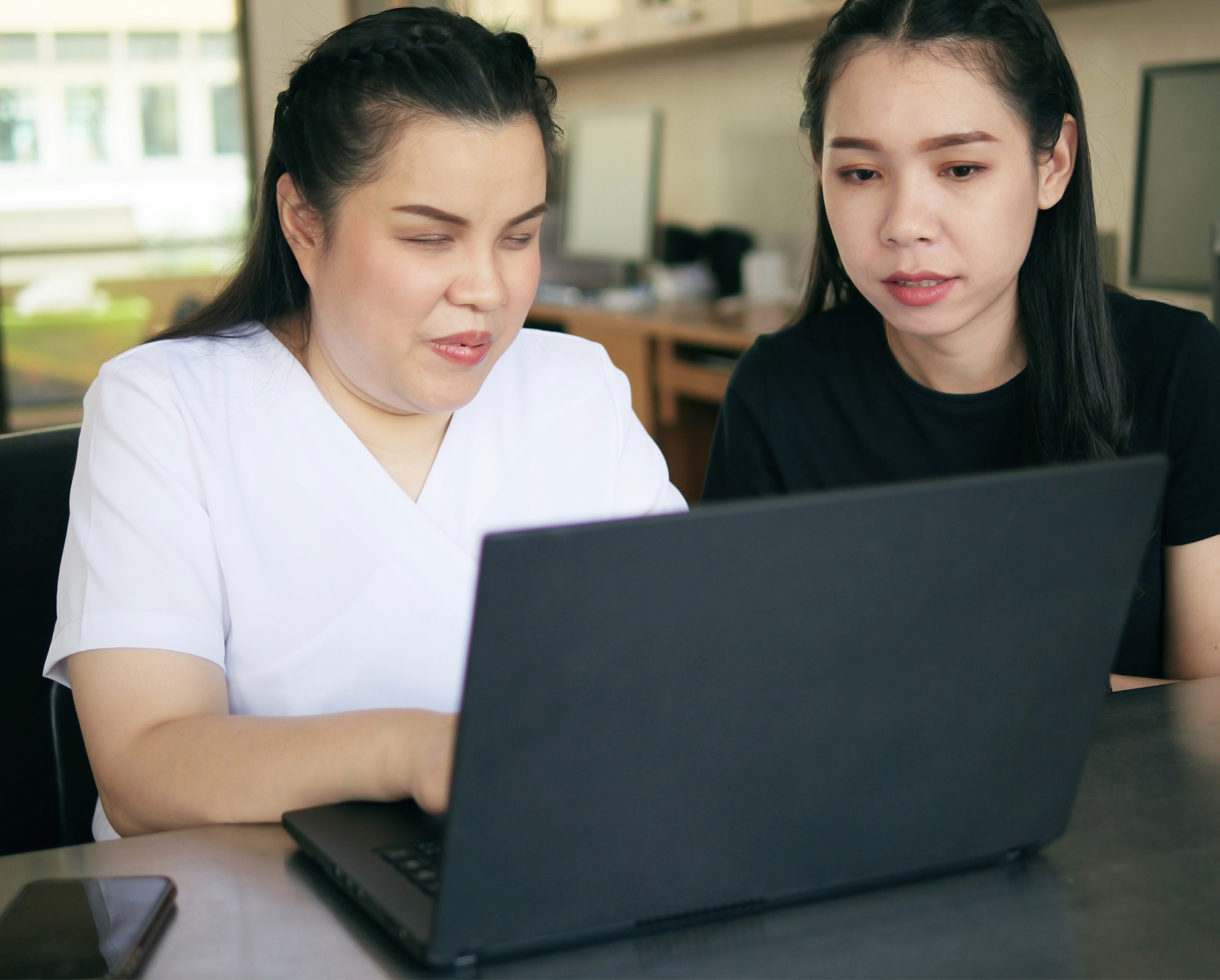 A blind woman uses a computer with her colleague.