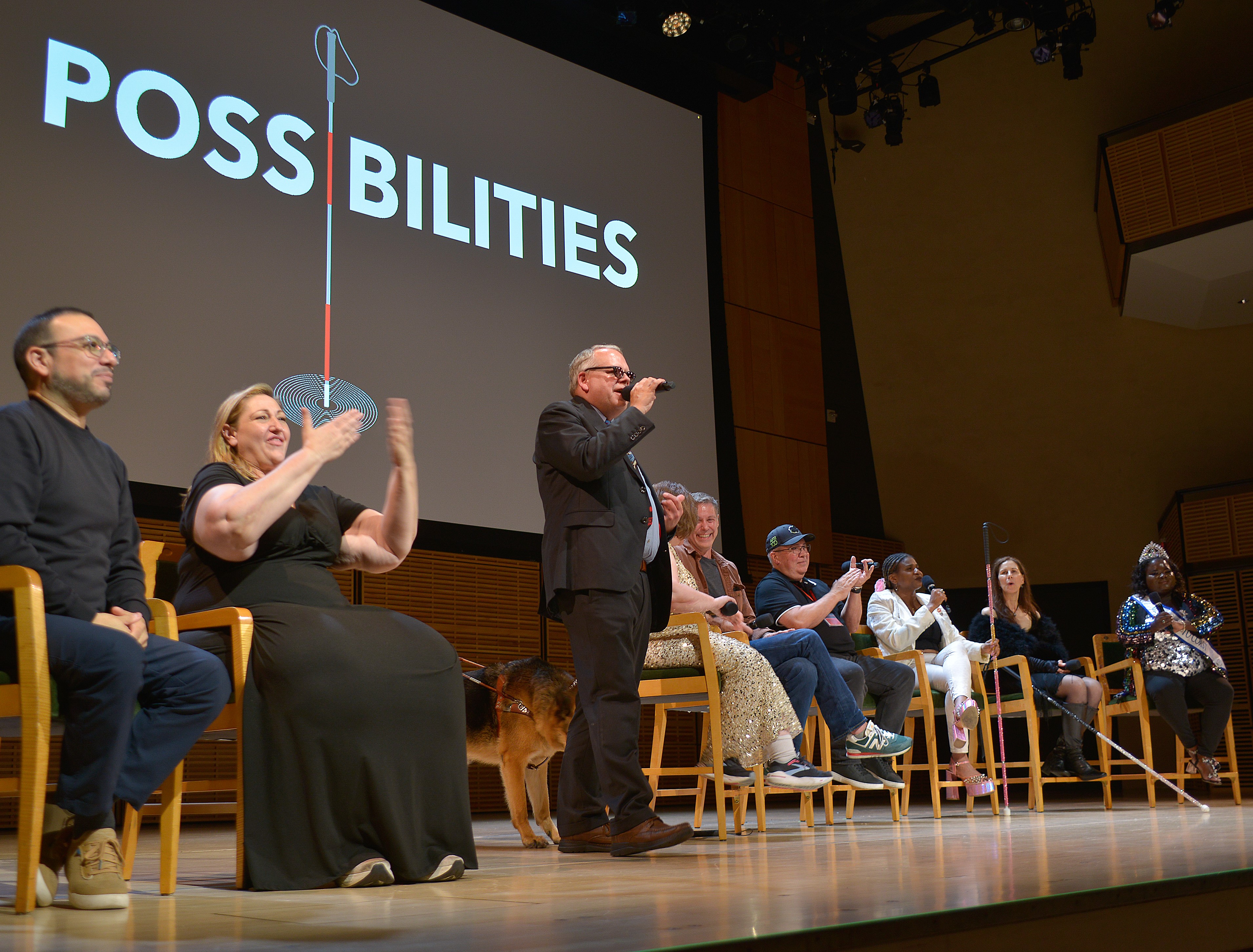 A large panel on the Carnegie Hall stage. The Possibilities logo sits on the big screen.