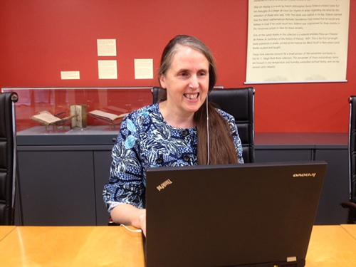 Crista Earl at her laptop, using headphones