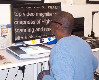 man reading with video magnifier