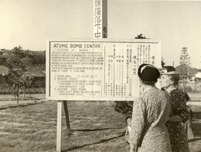 Helen Keller and Polly Thomson in front of a sign 