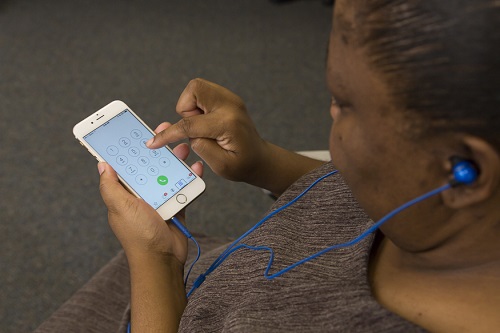 Woman using an iPhone with earbuds connected