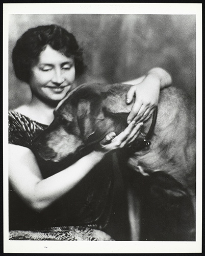 Helen Keller with her arms around a big dog, circa 1925