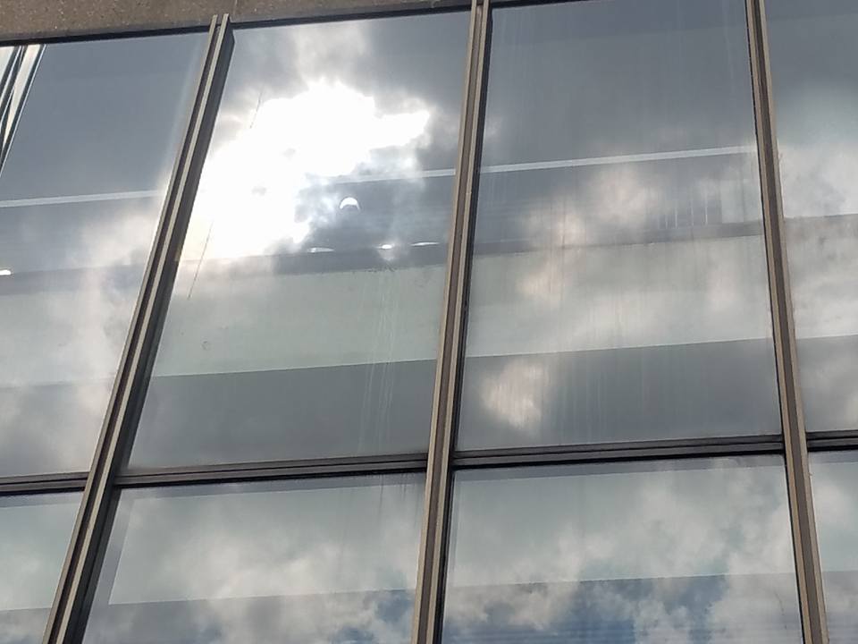 eclipse reflection captured on the windows of Madison Square Garden: a crescent-shaped sun gleams from the window