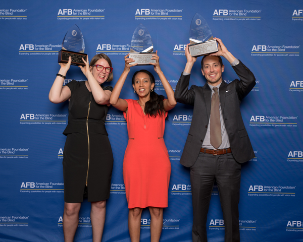 Holding their Helen Keller Achievement Awards above their heads, from left to right, Jenny Lay-Flurrie, Haben Girma, and Jeffrey Wieland.