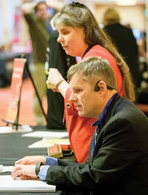 A seated man reading braille