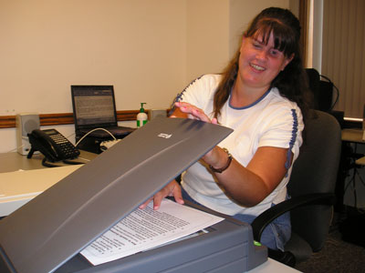 Photo of a woman placing a page on the SARA's scanning surface.
