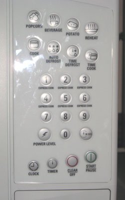 Closeup photo of microwave controls showing eight buttons labeled with such settings as "popcorn," "beverage," "potato," reheat," with small drawings on each button, as well as numbered buttons and four control buttons.
