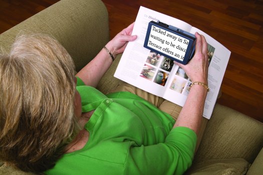 Photo of the Amigo being used to read text in a magazine.