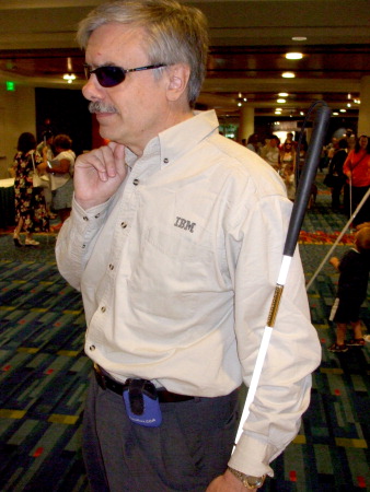 Guido Corona standing in a hallway at the 2007 NFB convention wearing an IBM shirt.