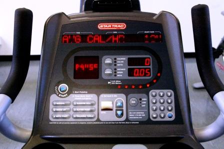 The stationary bike user interface consists of five flat panel touch pads, four small screen displays, and flashing indicator lights.
