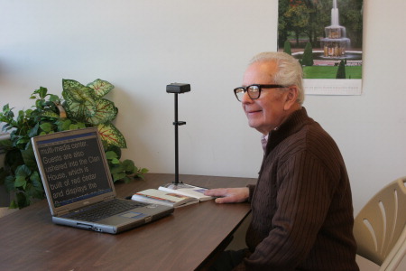 A man reading a book placed under the Zoom-Ex camera.
