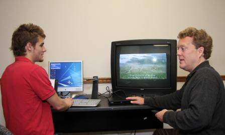 The author sets up a digital converter box while an intern takes notes.