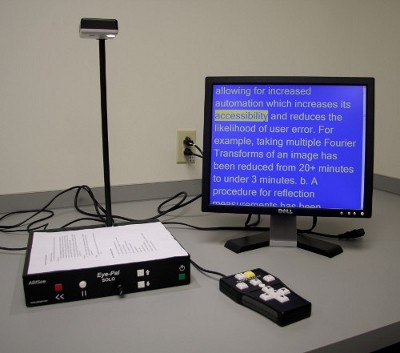 A photo of the Eye-Pal SOLO LV with a monitor displaying magnified text in high contrast colors.