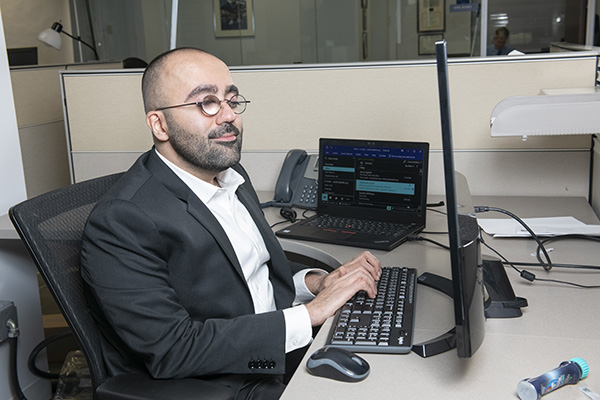 Amir Rahimi at his desk, typing 