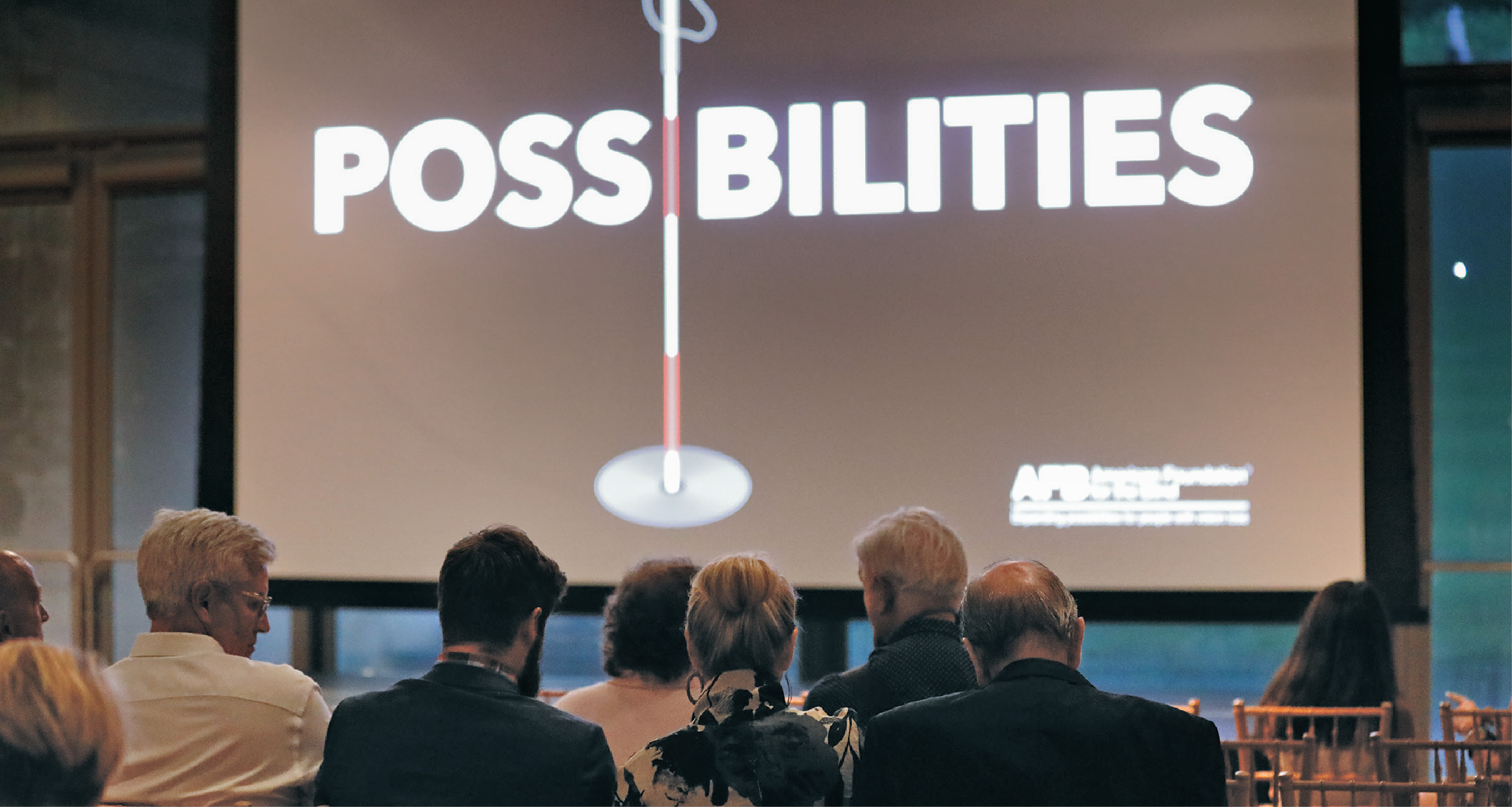 Audience members looking at a screen with the Possibilities documentary logo.